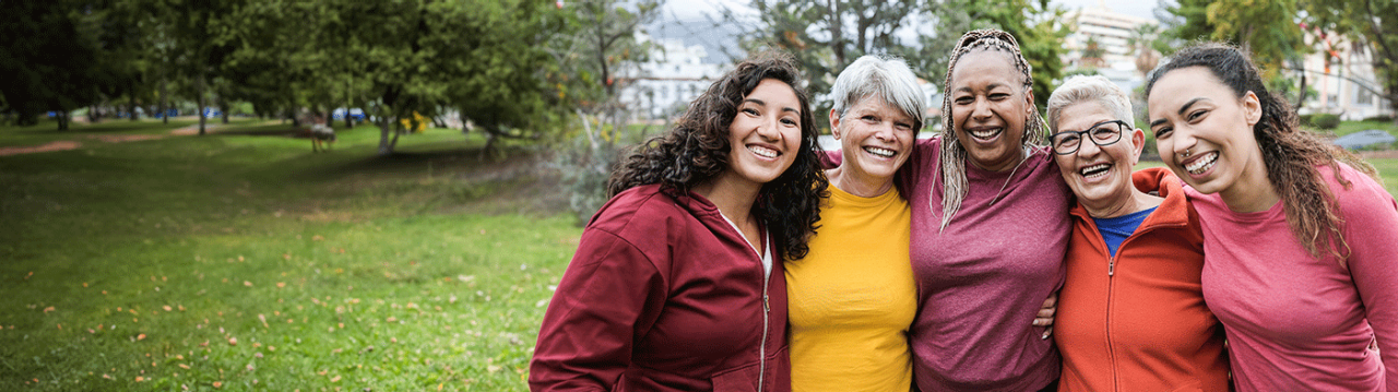 Women embracing outdoors at a park.